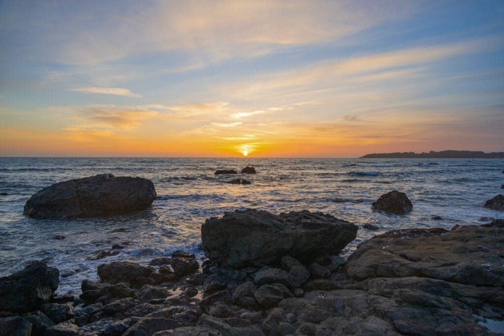 The sun is setting over the ocean at Pismo Beach.