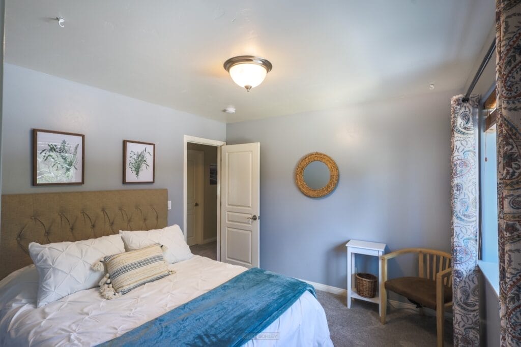 A vacation rental bedroom in Atascadero featuring a white bed and blue comforter.
