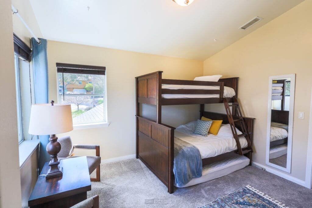 A vacation rental bunk bed in a bedroom with a window, located near Pismo Beach in Paso Robles.