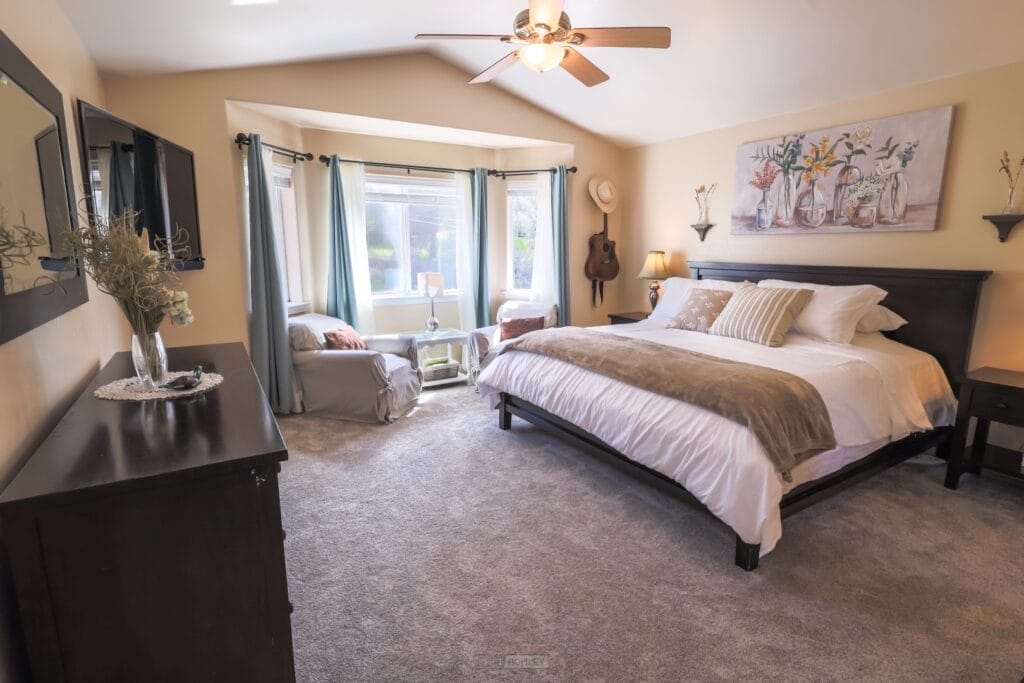 A vacation rental bedroom with a bed and a ceiling fan near Pismo Beach.
