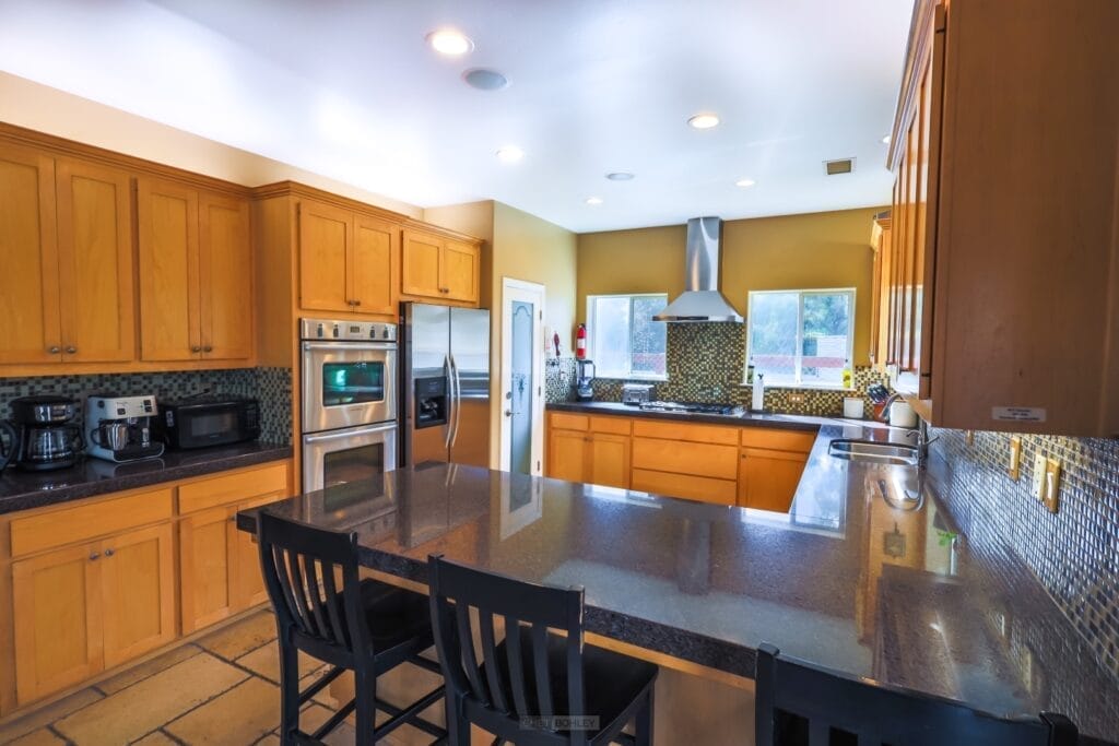 A kitchen with black countertops and wooden cabinets in the central coast region, near Morro Bay and Pismo Beach.