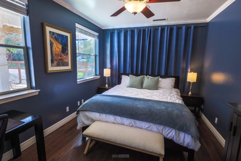 A bedroom with blue walls and a ceiling fan, located in Atascadero.