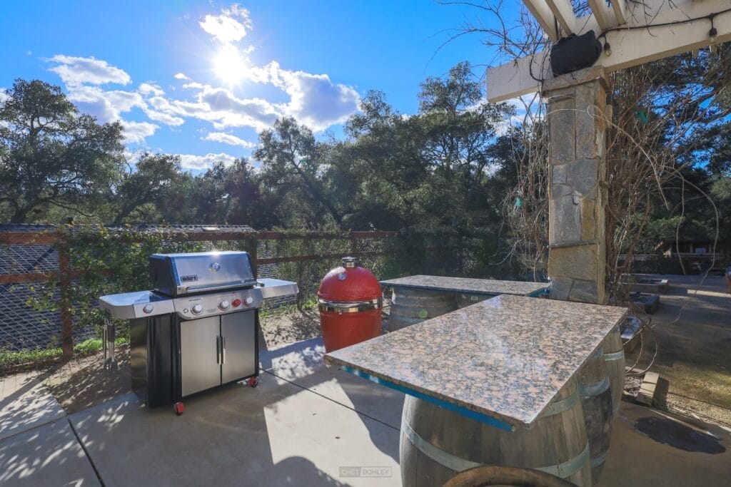 A patio with a bbq grill and a table located on the central coast.