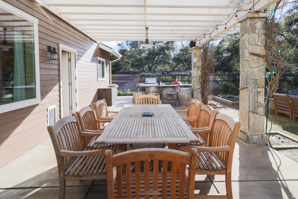 A central coast patio with a wooden table and chairs, perfect for your Paso Robles vacation rental.
