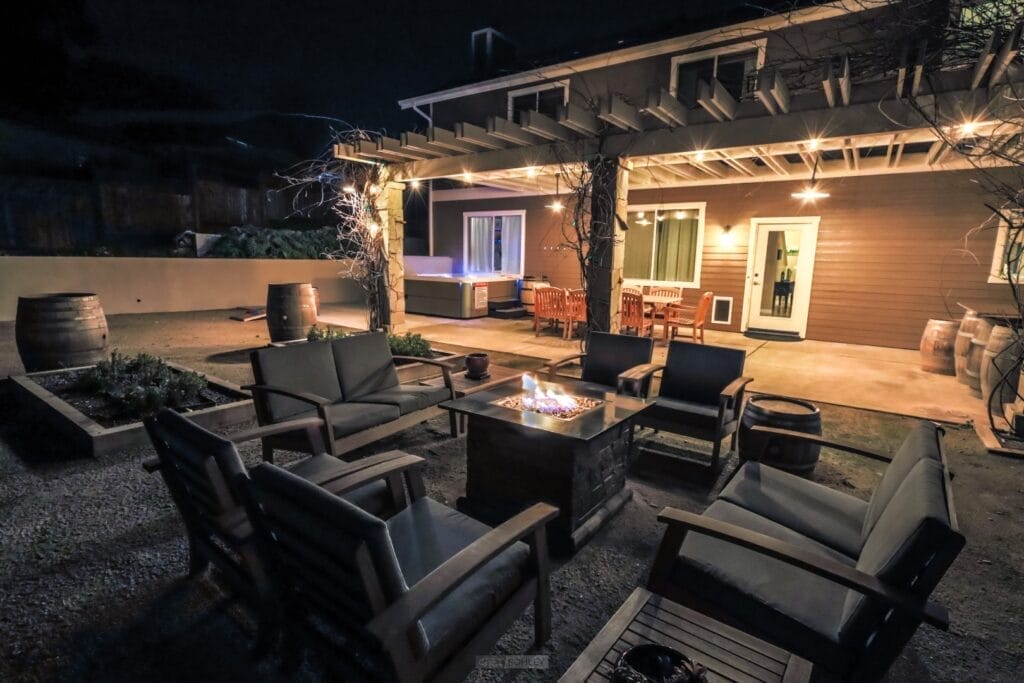 A patio with furniture and a fire pit in Paso Robles, perfect for a cozy vacation rental at night.