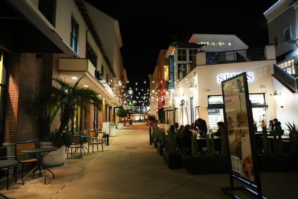 The sidewalk in Paso Robles is lit up at night.